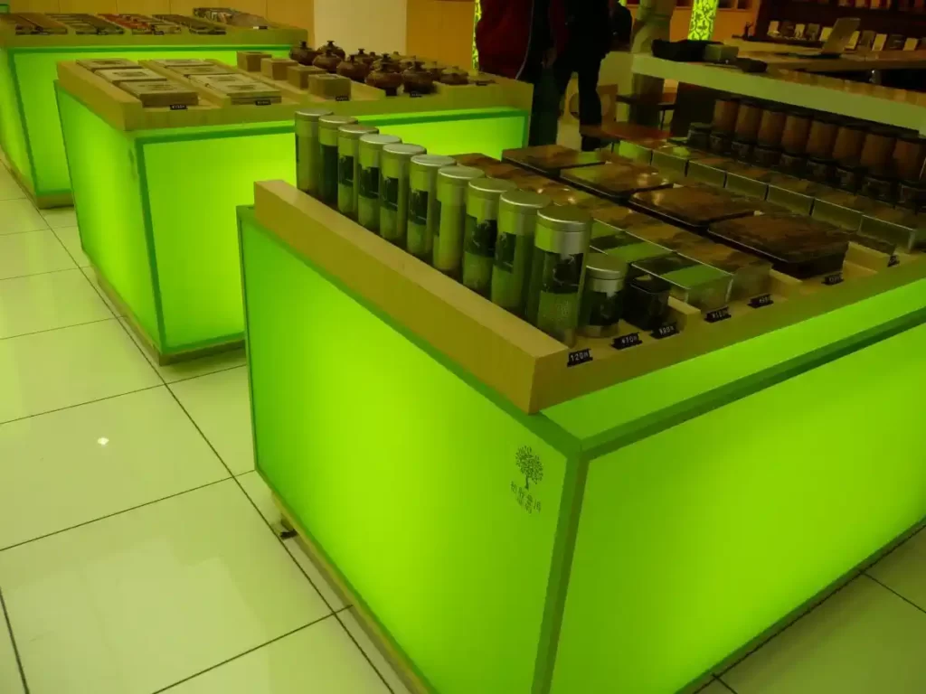 Veikala galdi ar izgaismotiem orgstikla sāniem zaļā krāsā
